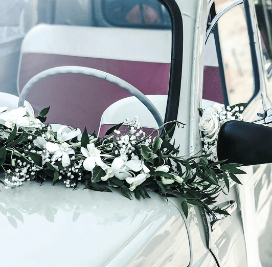 Décoration florale sur une voiture de mariage rose